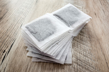 Tea bags on wooden background.