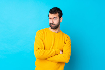 Young caucasian man over isolated blue background portrait