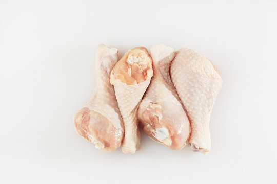 Raw chicken drumsticks on white background. Chicken legs. Top view. Food Background. Copy space. Cooking content. Uncooked meat. Meat shop.