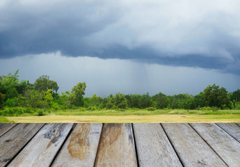Wooden floor and dark sky overcast background.