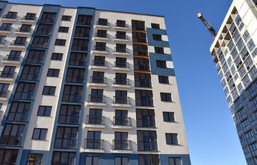 Construction of a new multi-storey building. The facade building with windows and balconies. The frame of the building is made of concrete. Residential building architecture background