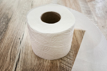 white toilet paper on a wooden background.