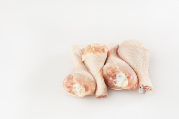 Raw chicken drumsticks on white background. Chicken legs. Top view. Food Background. Copy space. Cooking content. Uncooked meat. Meat shop.