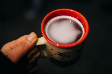 hand holding a cup with hot mulled wine on a christmas market in advent