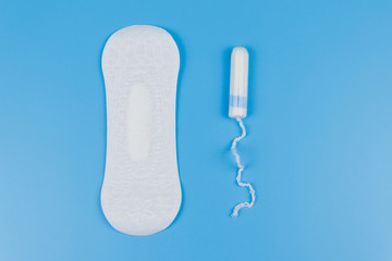 Sanitary pad and tampons on blue background. Top view © olyasolodenko