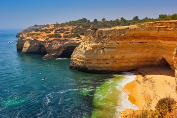 A picture of a beach with Atlanic ocean and its waves, sandstone cliffs and cliffs that forms...