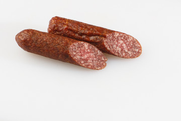 Industrial manufacture of sausages. Smoked sausage on a wooden rustic table with addition of fresh aromatic herbs and spices, natural product from organic farm, produced by traditional methods.