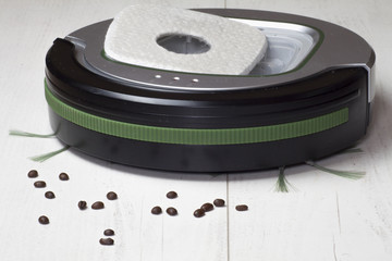 Automatyczny odkurzacz na białych panelach podłogowych, który sprząta ziarna kawy i inne zanieczyszczenia wymagające codziennego czyszczenia.

 - obrazy, fototapety, plakaty