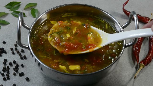 Spicy rasam is a popular south indian soup eaten by mixing with white rice.