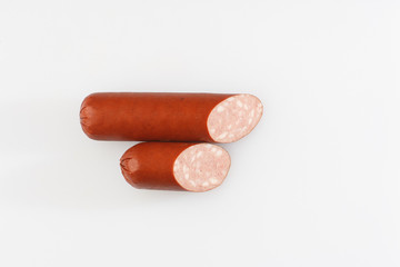 Industrial manufacture of sausages. Smoked sausage on a wooden rustic table with addition of fresh aromatic herbs and spices, natural product from organic farm, produced by traditional methods.