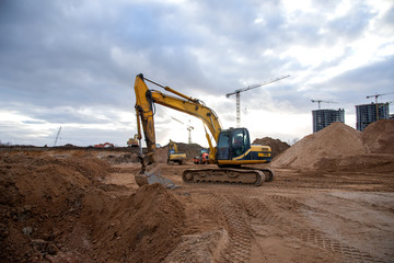 Excavator during earthmoving at construction site. Backhoe dig ground for the construction of...