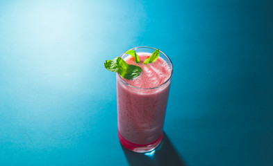Dramatic illuminated gloomy smoothie view over blue oil background with minimal looking, copy space