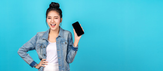 Banner of asian woman feeling happiness, blinks eyes and standing hold smartphone on blue...