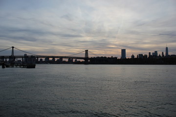 Obraz premium New york, USA - 20.12.2019: Brooklyn bridge in New York, Manhattan skyscrapers skyline behind across Hudson river at end of day New York, USA - stock photo