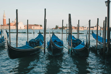 Obraz na płótnie Canvas Photograph of a set of gondolas parked on a pier in Venice