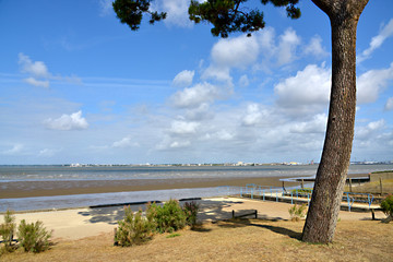 Beach at low tide of Saint Brevin les Pins in Pays de la Loire region in western France, and the town of Saint Nazaire in the background
