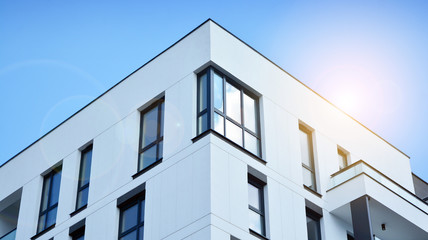 Modern apartment buildings on a sunny day with a blue sky. Facade of a modern apartment building. Glass surface with sunlight.