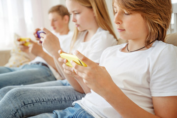 Obraz na płótnie Canvas Children teenagers play a game on the phone at home.