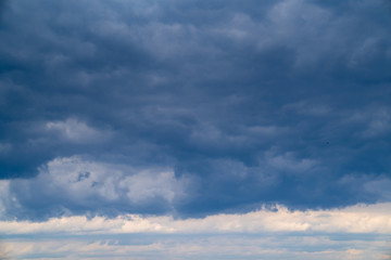Fototapeta premium dark grey cloudy sky with epic clouds above city. 