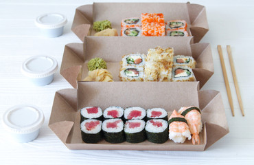 Lunch time concept. Japanese sushi in take away biodegradable boxes for dinner at home or at work. Close-up