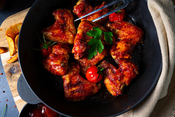 Spicy chicken wings in honey with potato wedges