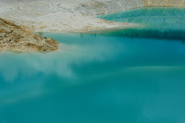 Obraz premium turquoise water and white shore in a kaolin quarry