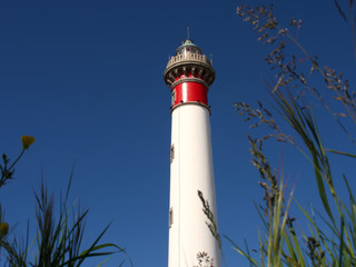Lighthouse on a background of blue sky, Ouistreham, France - obrazy, fototapety, plakaty