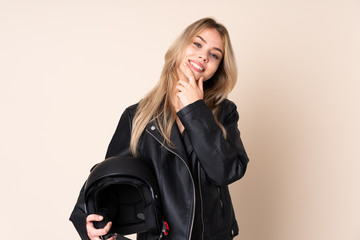 Russian girl with a motorcycle helmet isolated on beige background smiling