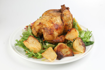 Whole roasted grilled chicken poultry bird with baked potato vegetable salad tomato lemon on white background