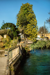 Fototapeta na wymiar Vertical view of wheel of water mill in Medieval village L'Isle-sur-Sorgue, Vaucluse, Provence, France. Famous Sorgue river with green water and provencal houses. Provence travel tourism destination.