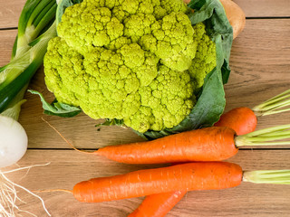 Organic vegetables, cauliflower, potatoes, onion, carrots on wooden table