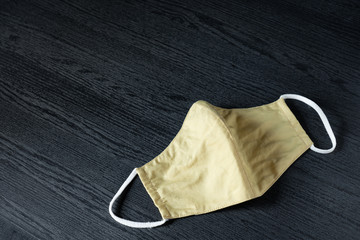 Disposable surgical face mask made from cotton fabric in colorful pastel color use cover mouth and nose, for protection against flu, corona virus(COVID-19) and other diseases on black background.