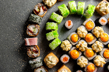 A large set of various rolls and sushi. Hats from the sauce. Baked rolls. Close-up