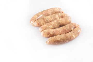 Raw pork beef sausages on white background. Traditional German homemade sausages. Delicious raw meat for barbecue. Advertising for meat shop and farm. Top view. Space for text