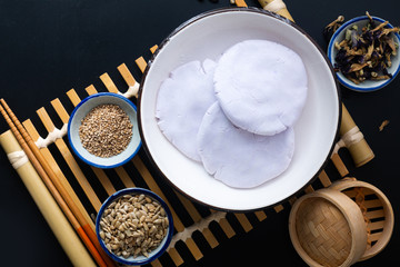 Healthy food concept Vegan Gluten free Homemade Asian fried glutinous rice flat pancake with sesame and sunflower seeds on black baclground with copy space