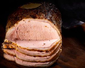 whole fried pork, gastronomic slices. on a dark wooden background. dark photo