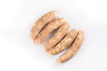 Raw pork beef sausages on white background. Traditional German homemade sausages. Delicious raw meat for barbecue. Advertising for meat shop and farm. Top view. Space for text