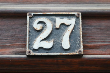 Vintage grunge square metal rusty plate of number of street address with number. Close up, brand