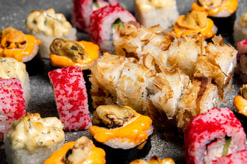Small set of baked and cold rolls. Sushi with fish. Gray background. Close-up