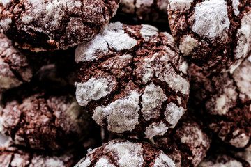 Chocolate cookies with cracks sprinkled with icing sugar.