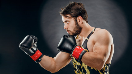 Plakat A man in Boxing gloves. A man Boxing on a black background. The concept of a healthy lifestyle