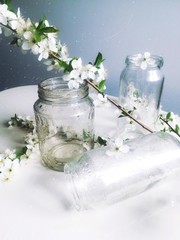 glass jars with water drops close up with a cherry blossom branch