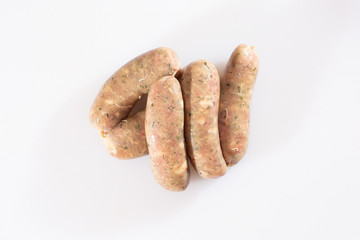 Raw pork beef sausages on white background. Traditional German homemade sausages. Delicious raw meat for barbecue. Advertising for meat shop and farm. Top view. Space for text