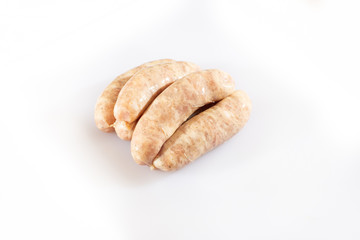 Raw pork beef sausages on white background. Traditional German homemade sausages. Delicious raw meat for barbecue. Advertising for meat shop and farm. Top view. Space for text