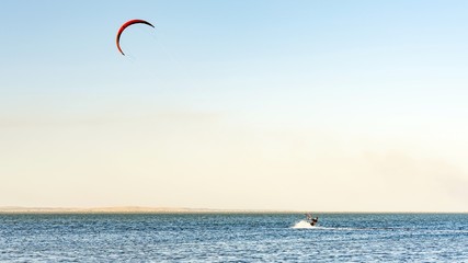 Man kitesurfer rides kite. Black Sea coast on sunny day. Blagoveshenskaya. Anapa, Russia.