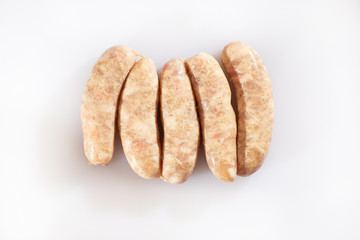 Raw pork beef sausages on white background. Traditional German homemade sausages. Delicious raw meat for barbecue. Advertising for meat shop and farm. Top view. Space for text