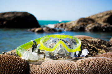 snorkel put on the rock seaside beach with shallow coral.