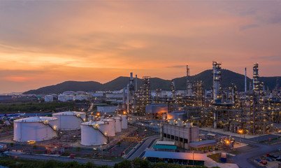 Aerial view Refinery and oil storage tanks at dusk and night. Petrochemical and energy oil industries..