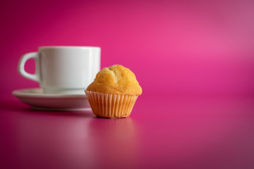 white cup of coffee with cupcake on background