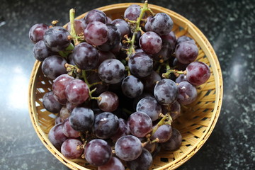 Close up of black grapes in a fruit basket.